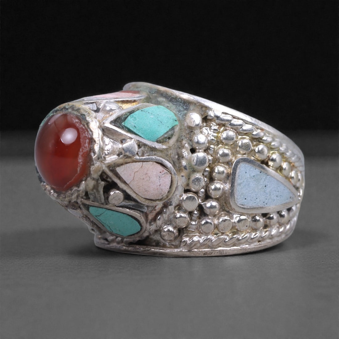 Silver Multi-Stone Ring - Red Cabochon Center, 59X: The ring is crafted in solid silver with a broad, tapering band and a prominently raised oval bezel. At the front is a polished red cabochon stone with a smooth, domed surface, secured within a thick