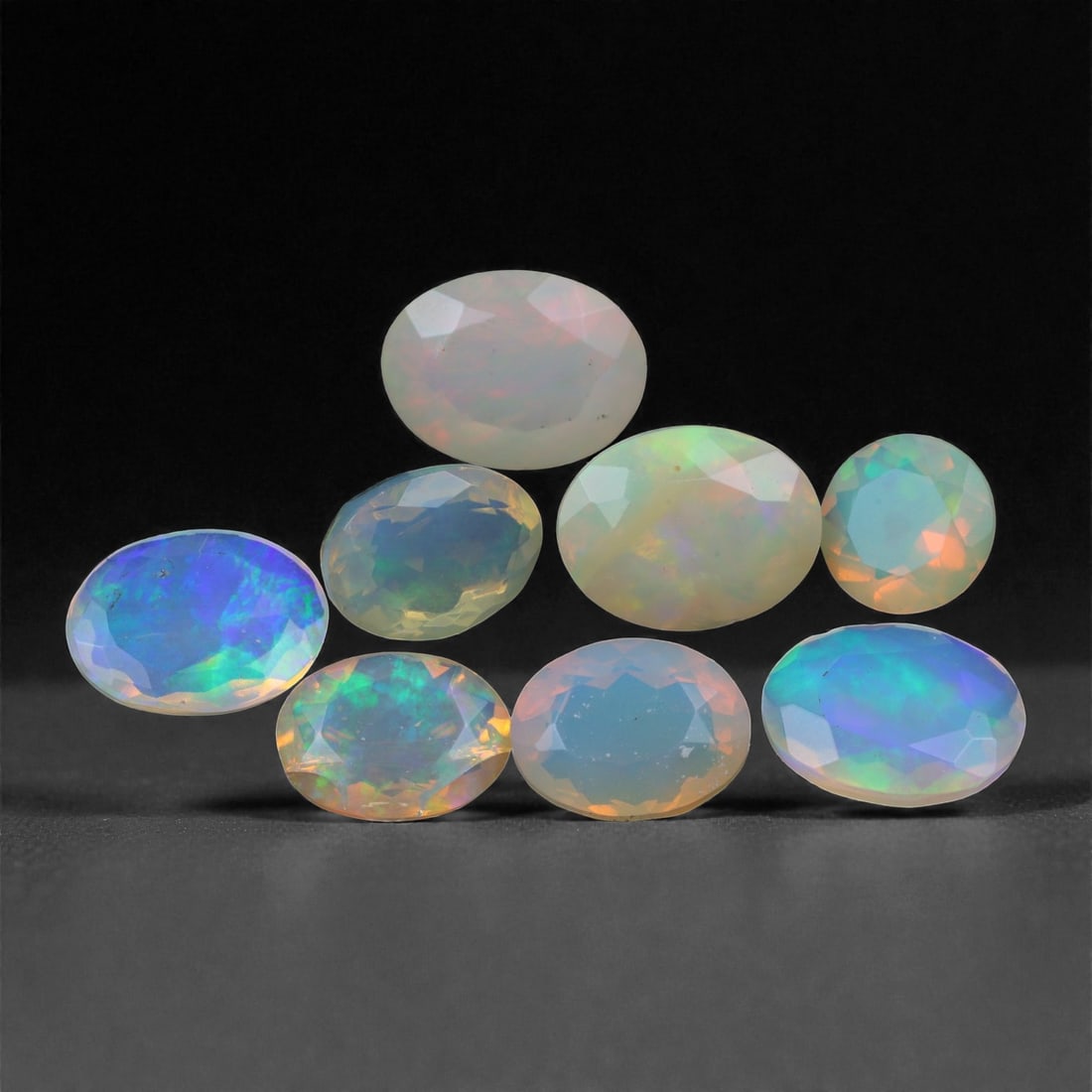 7.53 Carats Faceted Opal Selection - Natural Ethiopian Stones - 6 to 9mm, 14XA: This radiant lot of faceted opals delivers a stunning display of color play, with hues ranging from electric blue and violet to orange, green, and gold dancing across translucent to semi-crystal bodie