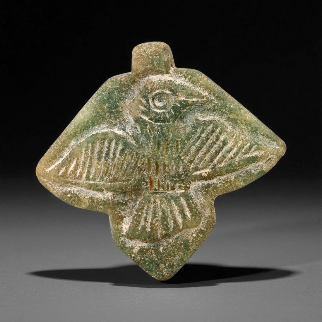 Ancient Mesopotamian Serpentine Bird Amulet, c. Neo-Sumerian Period, 5cm, 40ES: This elegant serpentine amulet, depicting a bird with outstretched wings, originates from the Neo-Sumerian period of Mesopotamia (circa 2100-2000 BCE). Birds held powerful symbolic significance across