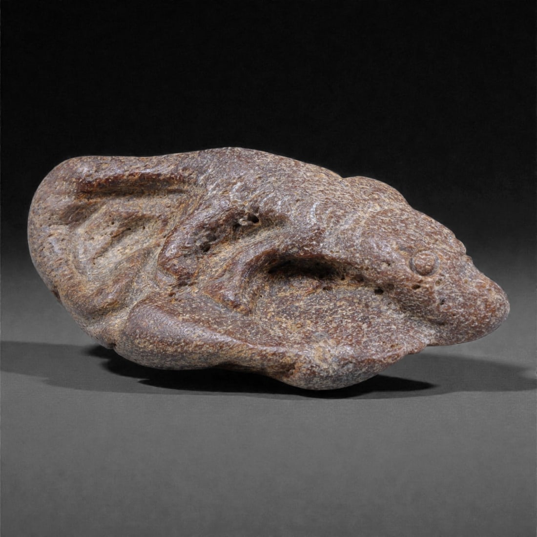 Ancient Fossil Bone Stone Crocodile Effigy - Zoomorphic Carving, 6F: This compact zoomorphic effigy is carved from dense fossilized bone stone and represents a crocodile rendered in a highly stylized, abstract manner. The elongated body, low profile, and forward-projec
