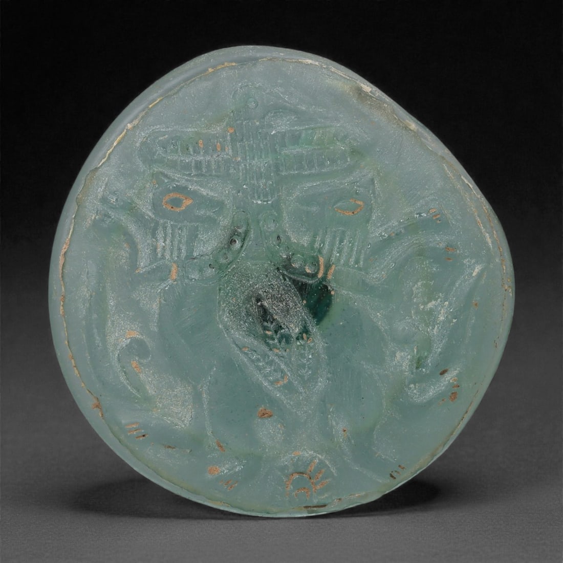 A Sasanian Green Glass Medallion with Anthropomorphic Mask, 3rd-7th Century CE, 25LP (1 of 2)