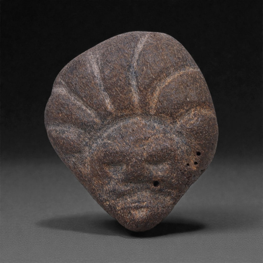 Ancient Fossilized Bone Stone Anthropomorphic Face - Near Eastern 4cm, 2ZD: Carved from fossilized bone stone, this miniature anthropomorphic face is rendered in a rounded, mask-like form with softly recessed eyes, a subtle nose ridge, and a compressed mouth, the features eme