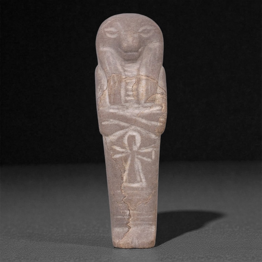 Egyptian Revival Stone Idol - Mummiform Figure with Ankh Motif, 43F: Carved from pale brown stone with a fine, compact texture, this mummiform figure is rendered in a vertically elongated form with a rounded head, softly modeled facial features, and arms crossed over t