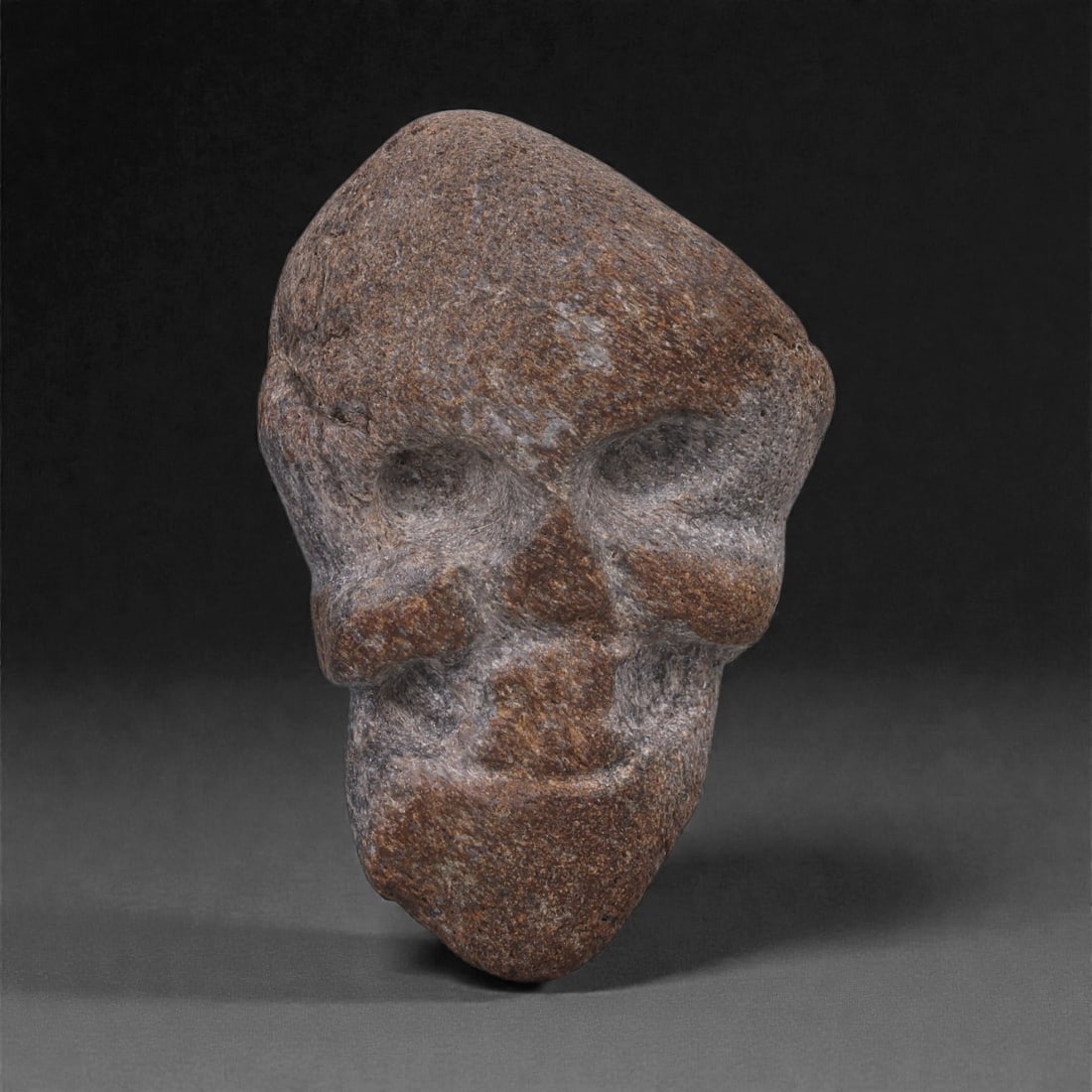 Ancient Fossilized Bone Stone Anthropomorphic Head - Near Eastern Figurine 5.3cm, 14ZD: Carved from fossilized bone stone, this compact anthropomorphic head is rendered in a strongly modeled, mask-like form with deeply recessed eyes, a broad nose, pronounced cheek planes, and a tapering