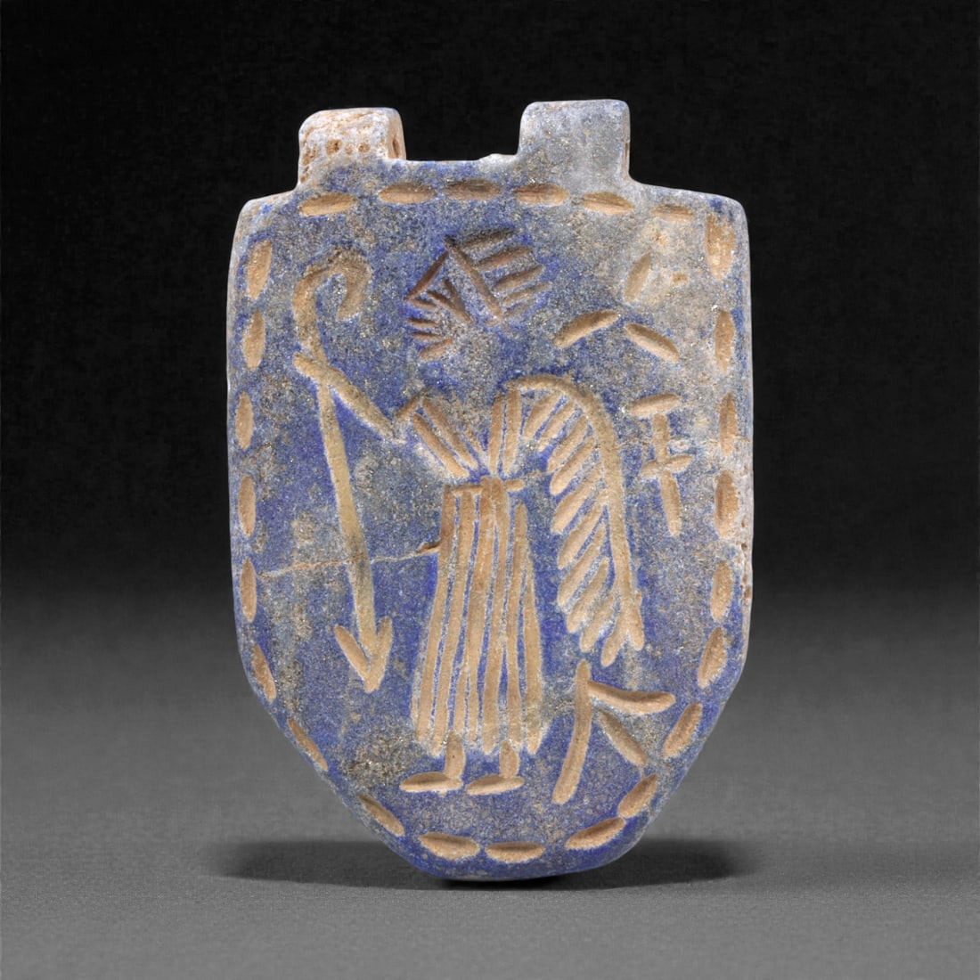 A Sasanian Lapis Lazuli Amulet, 3rd-7th Century CE, 4.4cm, 4Q: Carved from deep blue lapis lazuli with visible lighter inclusions and natural granular texture, the object is finished with a flat reverse and a front surface worked in low relief. The carving is exe