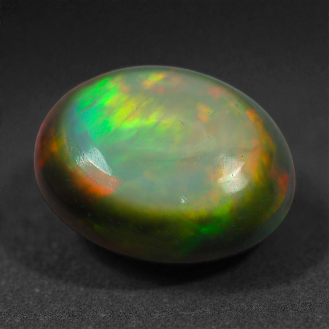 1.20 Carats Natural Welo Origin Smoked Black Opal Cabochon Gems, 9mm, 70M: This natural smoked black opal hails from the Welo region of Ethiopia, a source renowned for producing some of the world's most visually captivating opals. Through a careful and controlled smoking pro