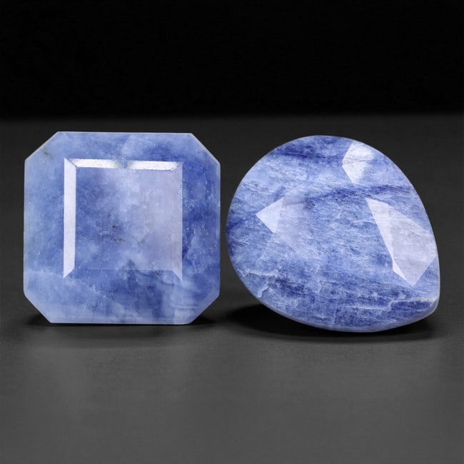 A Pair of Blue Sodalite Gemstones, Contemporary 17.33 Carats, 33XE: Cut from natural sodalite, the pair includes one square-cut stone with chamfered corners and one pear-shaped stone, each displaying characteristic blue and white veining. Both pieces are fashioned wit