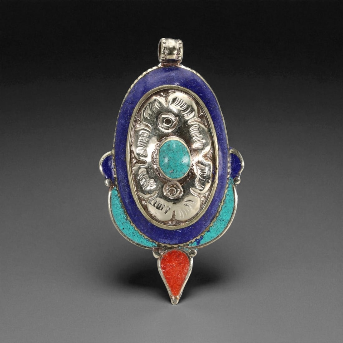 Tibetan Lotus Eye Pendant with Turquoise Lapis Coral Inlay, Silver Alloy, 34g, 40K: This elegant Tibetan pendant merges sacred floral imagery with protective symbolism in a vertically elongated form. Centered within a raised silver alloy bezel is a stylized lotus blossom, its petals