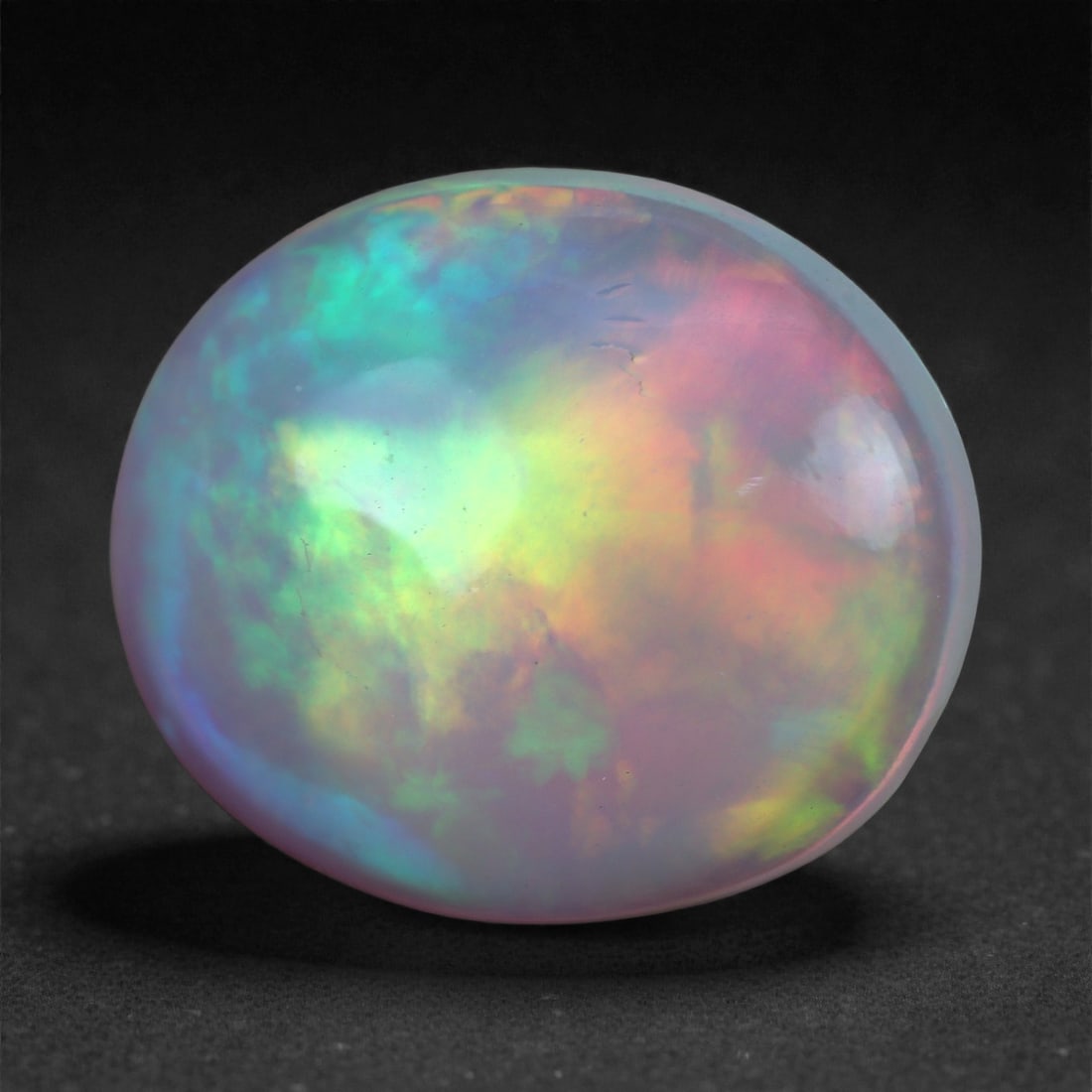 2.88 Carats Play-of-Color Welo Opal - Natural Ethiopian Gem 13x10mm, 95XA: This captivating Welo opal gleams with a luminous cascade of multi neon color that ripple across the stone's surface with every movement. The play-of-color is vivid and well-distributed, presenting a 