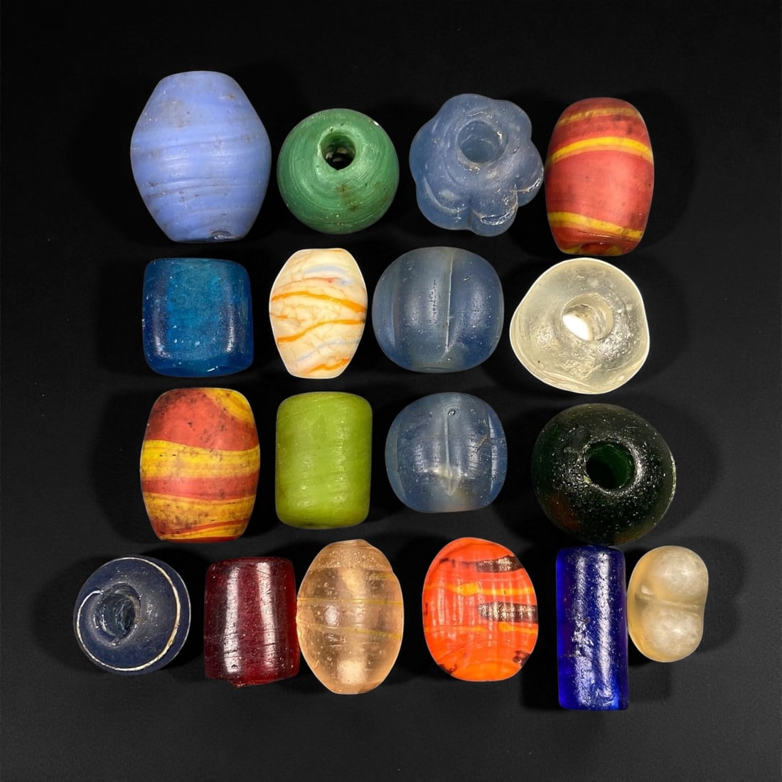 Antique Venetian and European Trade Glass Beads, c. 18th-19th Century, 1.5-2.1cm, 94EF: This captivating assemblage of antique glass beads originates from the flourishing European trade of the 18th-19th centuries, centered around Venice and Bohemia. Crafted in vibrant hues of amber, coba