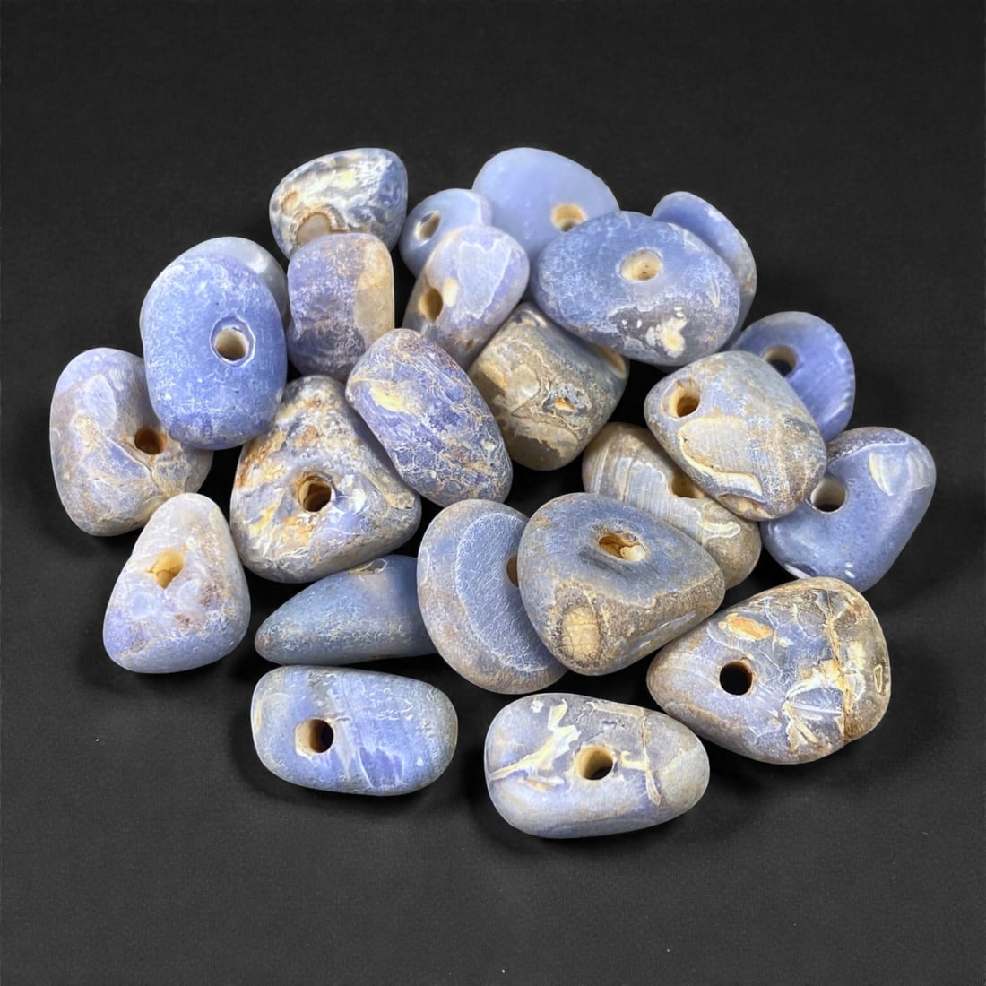Mediterranean Chalcedony Beads, 6th-4th Century BCE, 1-1.5cm, 11L: Formed from mottled blue-grey chalcedony with natural banding, the group comprises multiple small, irregularly shaped beads drilled longitudinally with conical perforations. The surfaces show ancient 