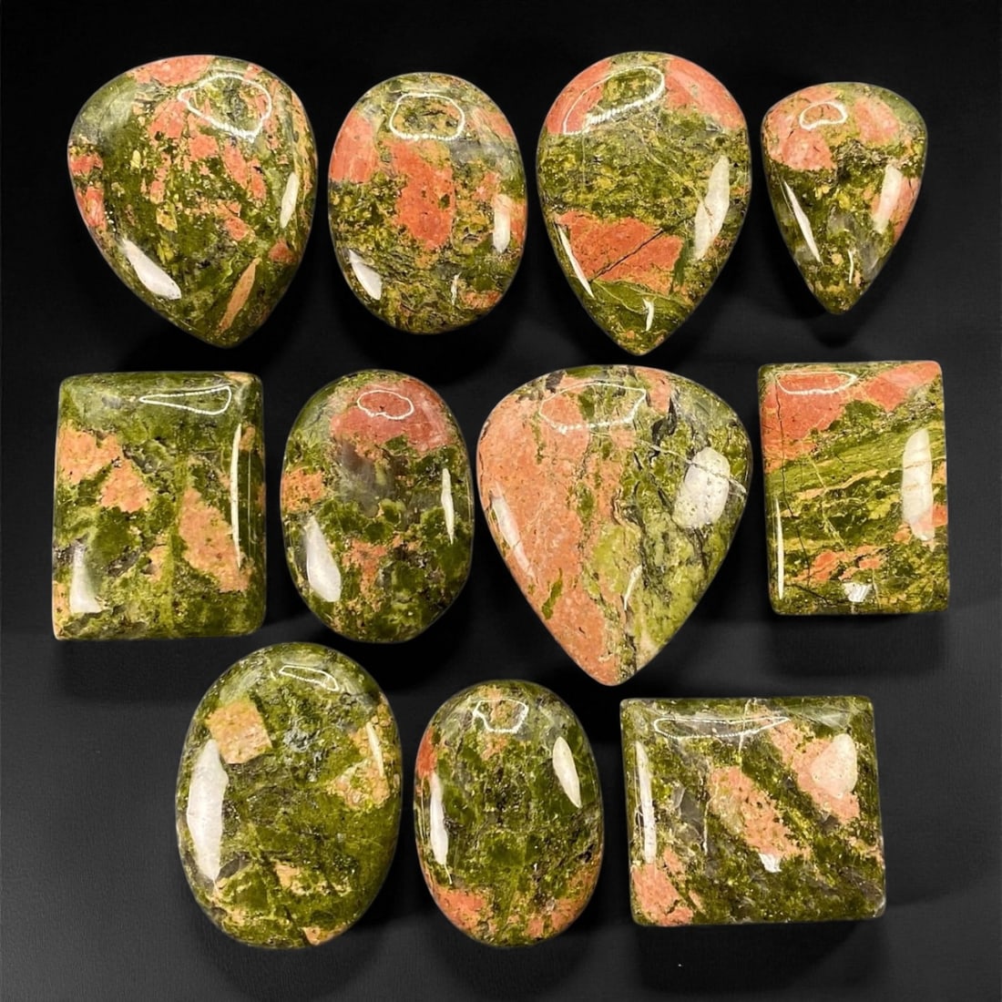 Unakite Jasper Cabochon Parcel - Natural 11-Piece Lot, 2.6 to 3.7 cm, 39XE: A richly textured medley of earthy beauty, this 11-piece parcel of unakite jasper cabochons blends forest greens and rosy terracotta hues in swirling, organic harmony. Each stone presents a mosaic of