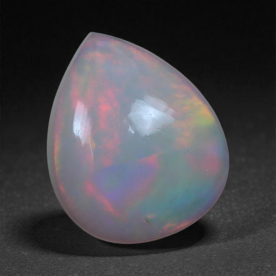 2.34 Carats Play-of-Color Welo Opal - Natural Ethiopian Gem 12x10mm, 32XC: This captivating Welo opal gleams with a luminous cascade of multi neon color that ripple across the stone's surface with every movement. The play-of-color is vivid and well-distributed, presenting a 
