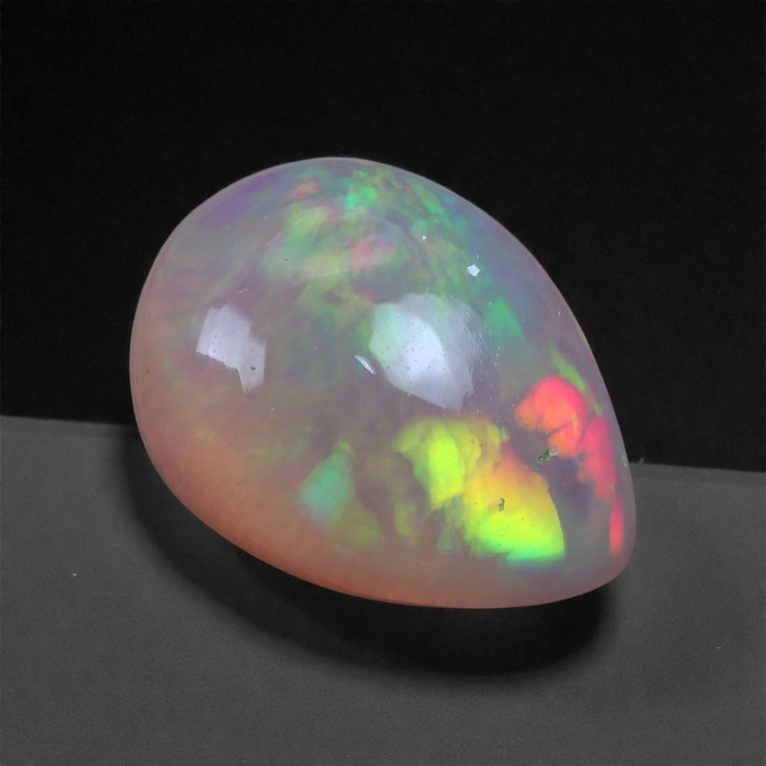3.10 Carats Play-of-Color Welo Opal - Natural Ethiopian Gem 13x9mm, 41XA: This captivating Welo opal gleams with a luminous cascade of multi neon color that ripple across the stone's surface with every movement. The play-of-color is vivid and well-distributed, presenting a 