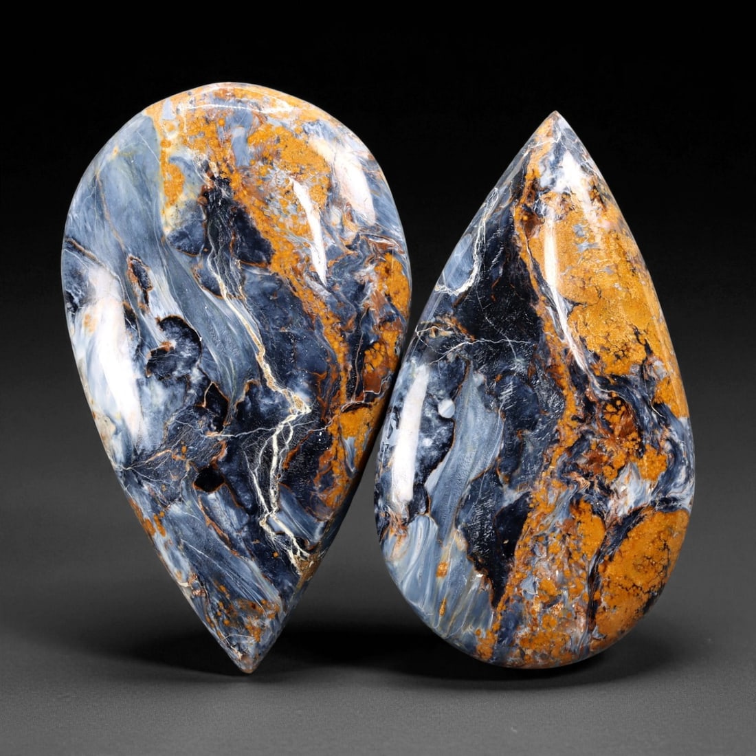 119.05 Carats Golden-Blue Pietersite Cabochon Pair - Natural Elongated Teardrops, 4.4 x 2.6 cm, 57XE: A masterclass in natural contrast and movement, this impressive pair of Pietersite cabochons blends deep indigo, swirling slate, and ochre-gold with lightning-like mineral veining across both surfaces