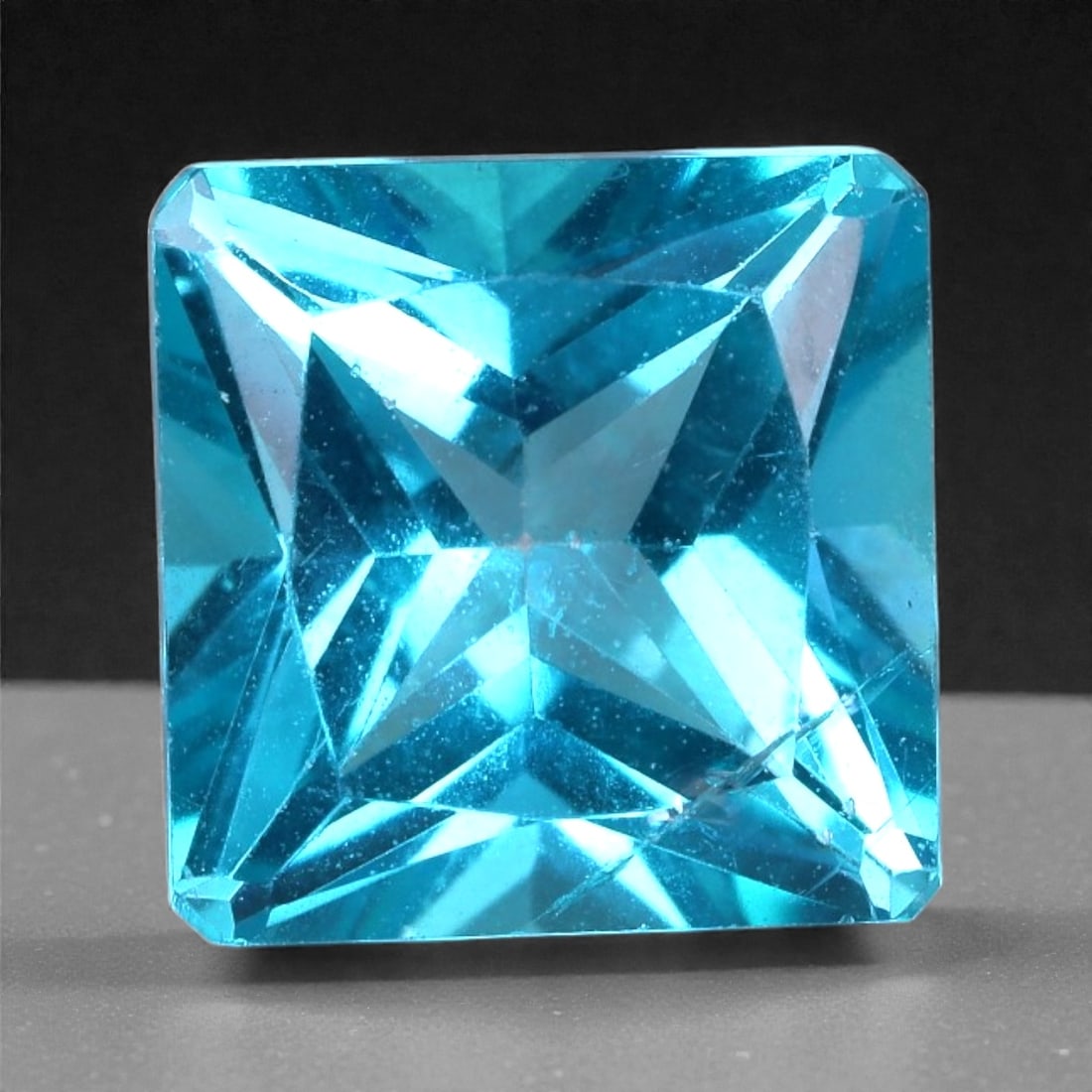 3.18 Carats Paraiba Blue Topaz Princess Cut - Natural Brazilian Gem, 66XB: This striking 3.18 carat topaz glows with a vivid Paraiba-like blue, expertly rendered in a sharp princess cut that enhances its brilliant symmetry. Measuring 8.1 x 5.4 mm, the gem features crisp corn