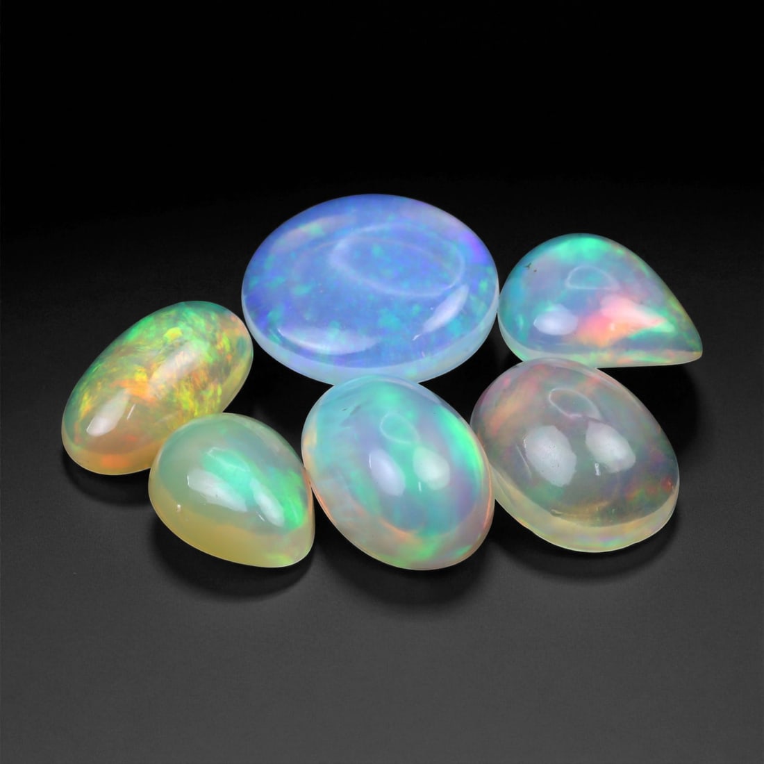 11.23 Carats Neon Play-of-Color Opal Selection - Natural Ethiopian Cabochons - 9 to 12 mm, 32XE: This luminous selection of opals radiates a dynamic spectrum of neon hues, with flashes of electric green, vivid orange, and spectral blue dancing across each dome. Their translucent base allows the i