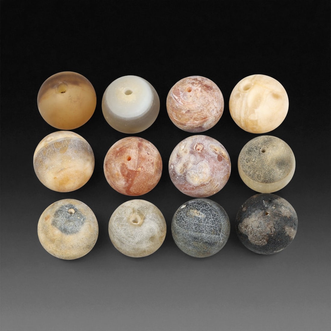 Antique Tibetan Agate and Chalcedony Prayer Beads Collection, c. 18th-19th Century, 1.5-1.6 cm, 99EM: This graceful assemblage of antique Tibetan beads, carved from agate and chalcedony, dates to the 18th-19th century and embodies the quiet spiritual refinement of Himalayan craftsmanship. Each bead is