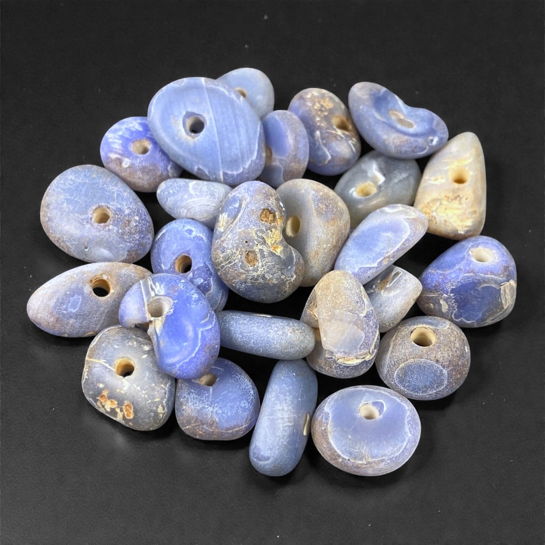 Mediterranean Chalcedony Beads, 6th-4th Century BCE, 1-1.8cm, 8L: Formed from mottled blue-grey chalcedony with natural banding, the group comprises multiple small, irregularly shaped beads drilled longitudinally with conical perforations. The surfaces show ancient 