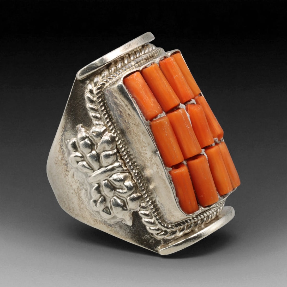 Antique Central Asian Coral Mosaic Silver Ring, c. 19th-20th Century, US 8, 16BD: This exceptional antique ring exemplifies the luxurious artistry of Central Asian adornment, featuring a rectangular bezel meticulously set with rows of natural coral segments. Each coral piece, vivid