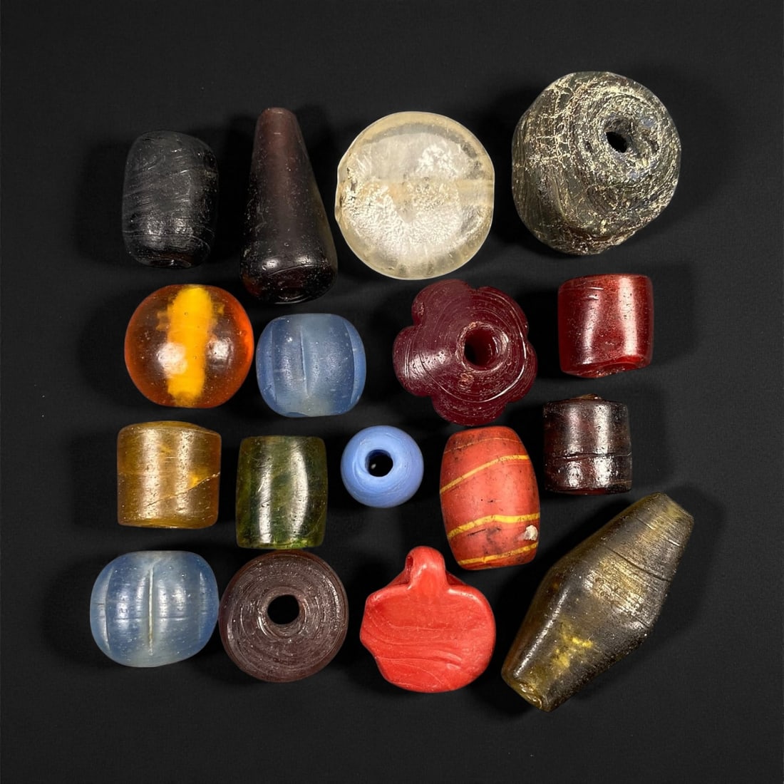 Antique Venetian and European Trade Glass Beads, c. 18th-19th Century, 1.1-3.5cm, 85EF: This captivating assemblage of antique glass beads originates from the flourishing European trade of the 18th-19th centuries, centered around Venice and Bohemia. Crafted in vibrant hues of amber, coba