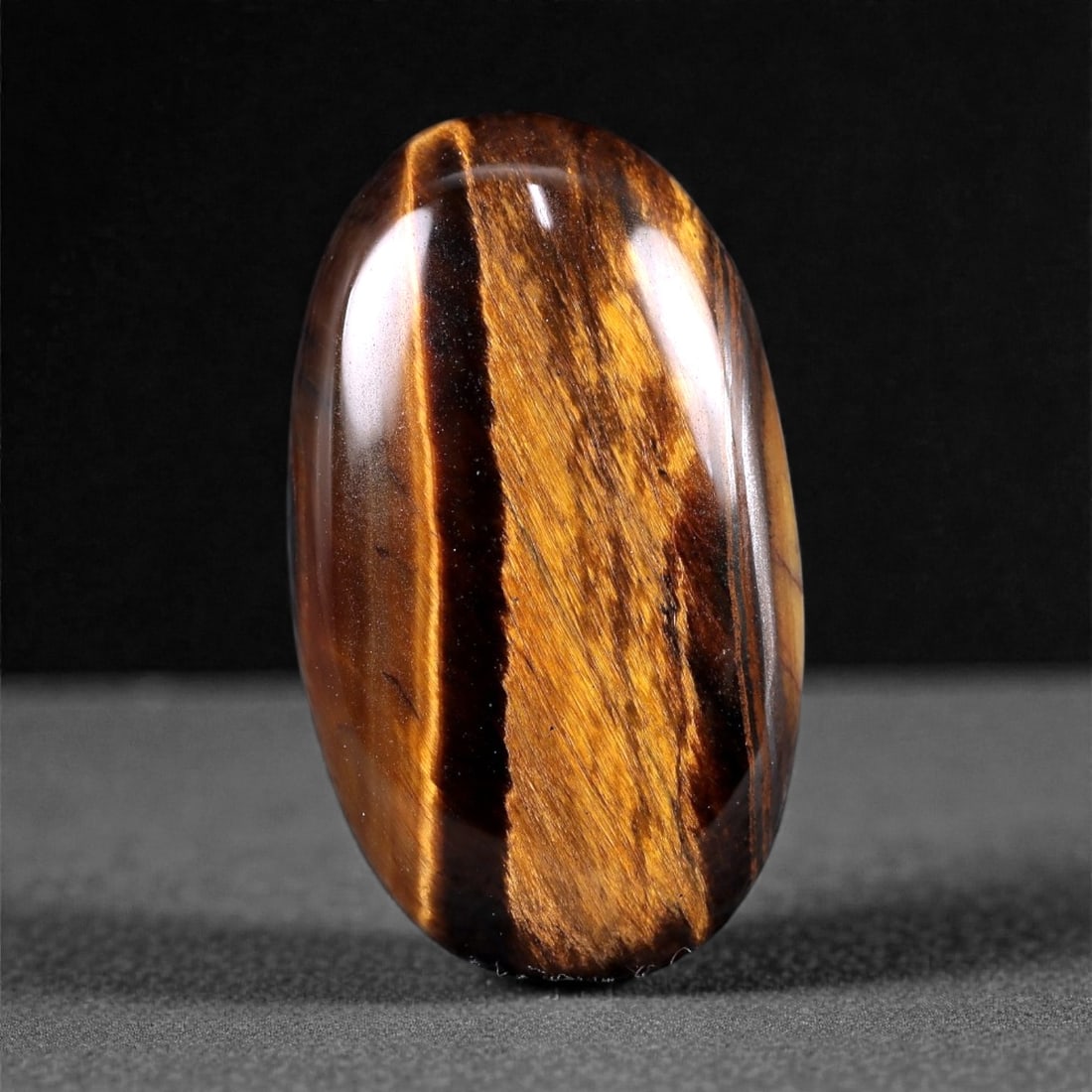 27.44 Carats Golden Brown Tiger's Eye Cabochon - Natural South African Gem, 48XC: This striking 28 x 16 mm Tiger's Eye cabochon displays bold bands of golden ochre and deep brown, shimmering with the signature silky chatoyancy that makes this gem instantly recognizable. The surface