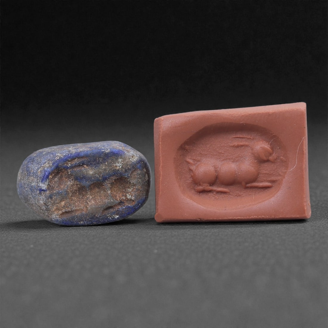 A Near Eastern Lapis Lazuli Hemispherical Stamp Seal, 3rd Millennium BCE, 1.8cm, 12N: Carved from lapis lazuli with mottled blue coloration and lighter mineral inclusions, the seal is hemispherical in form with a flat engraved base and a gently domed upper surface. A small perforation 