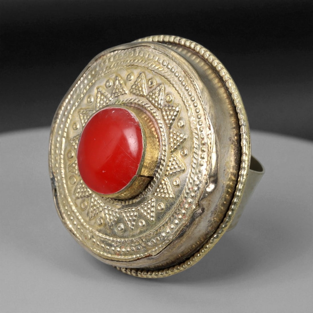 Vintage Himalayan Tribal Red Carnelian Brass Ring, 20th Century, US Size 8.25, 81XD: This striking vintage Himalayan ring exemplifies the bold and spiritual design language of traditional tribal jewelry from Nepal and Tibet. Handcrafted in brass, the ring features a prominent domed be