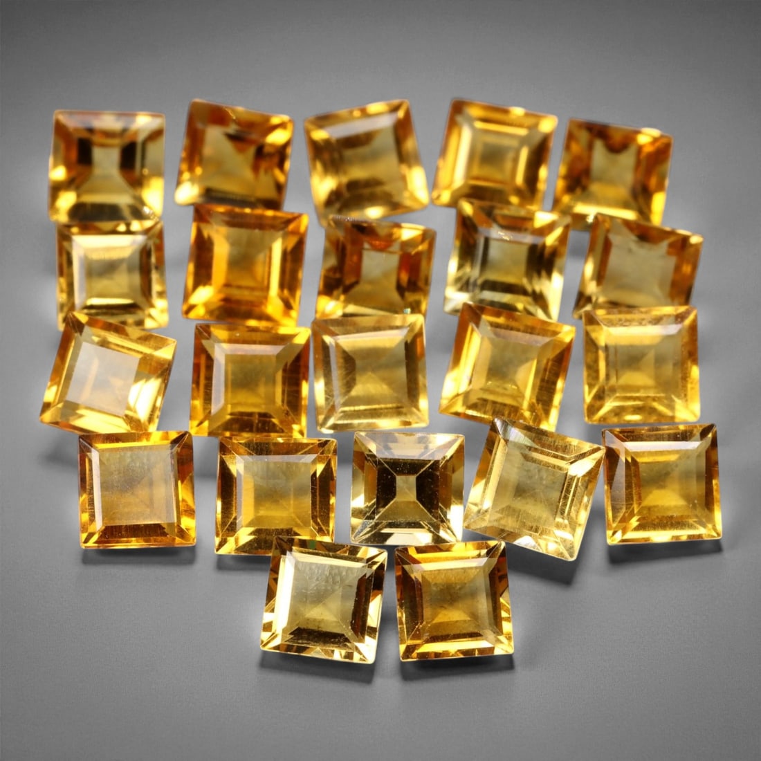7.69 Carats Golden Citrine Square Lot - Natural 4mm Princess Cuts, 22-Piece Parcel, 25XE: This radiant parcel of twenty two golden citrine gems features expertly cut princess squares, each measuring a crisp 4mm. With bright, sunlit tones ranging from golden honey to warm amber, the stones