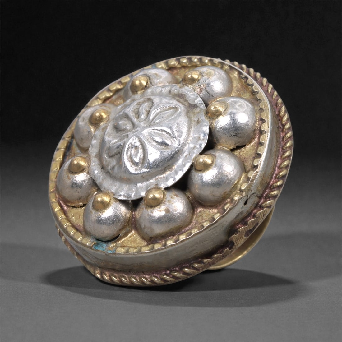 Himalayan Silver Ring - Repousse Cluster Jewelry, 3.5cm, 46X: The ring is constructed from silver, built up in a domed circular cluster with repousse and applied elements. The central oval panel is raised and decorated with chased linear motifs, framed by a scal