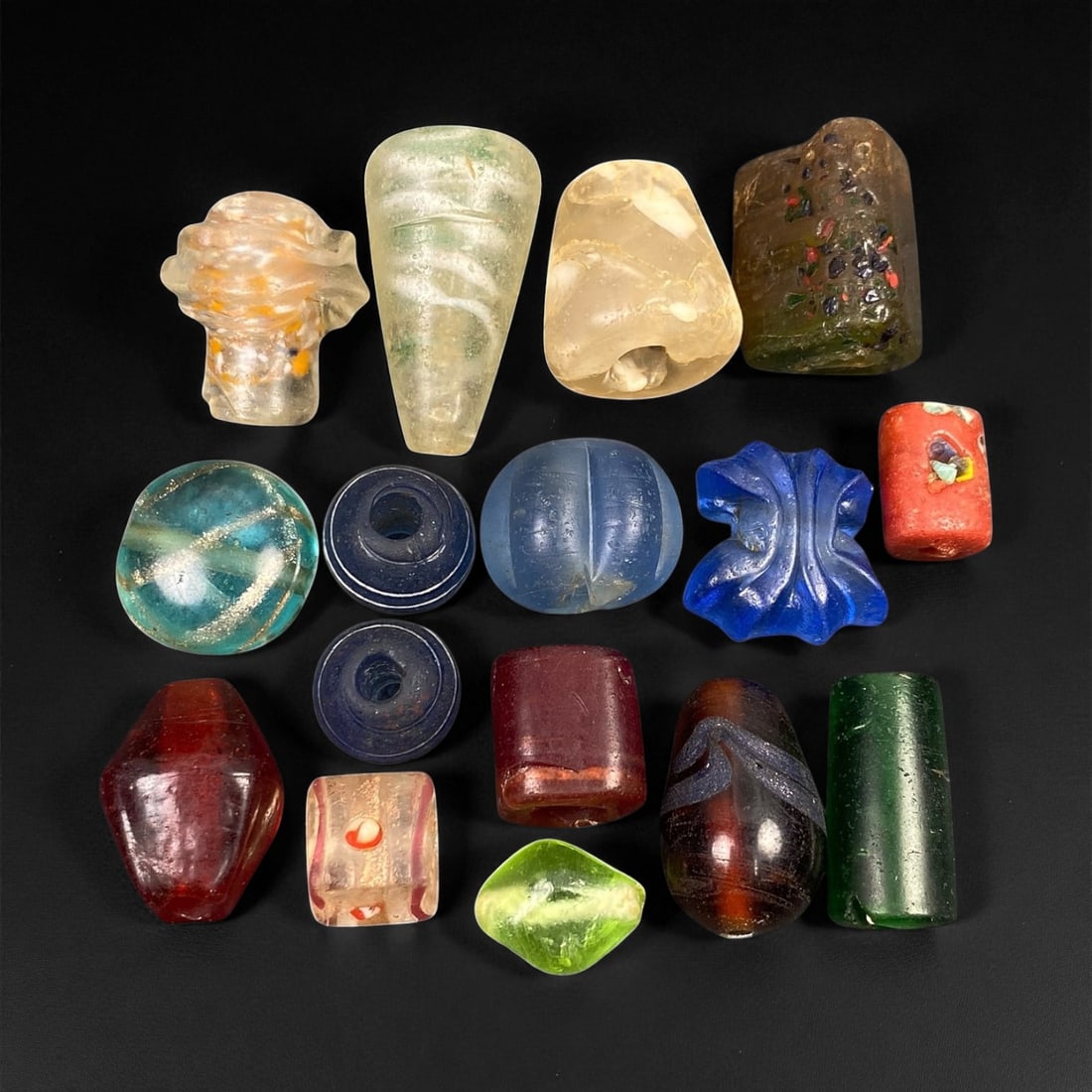 Antique Venetian and European Trade Glass Beads, c. 18th-19th Century, 1.2-3.3cm, 71EF: This captivating assemblage of antique glass beads originates from the flourishing European trade of the 18th-19th centuries, centered around Venice and Bohemia. Crafted in vibrant hues of amber, coba