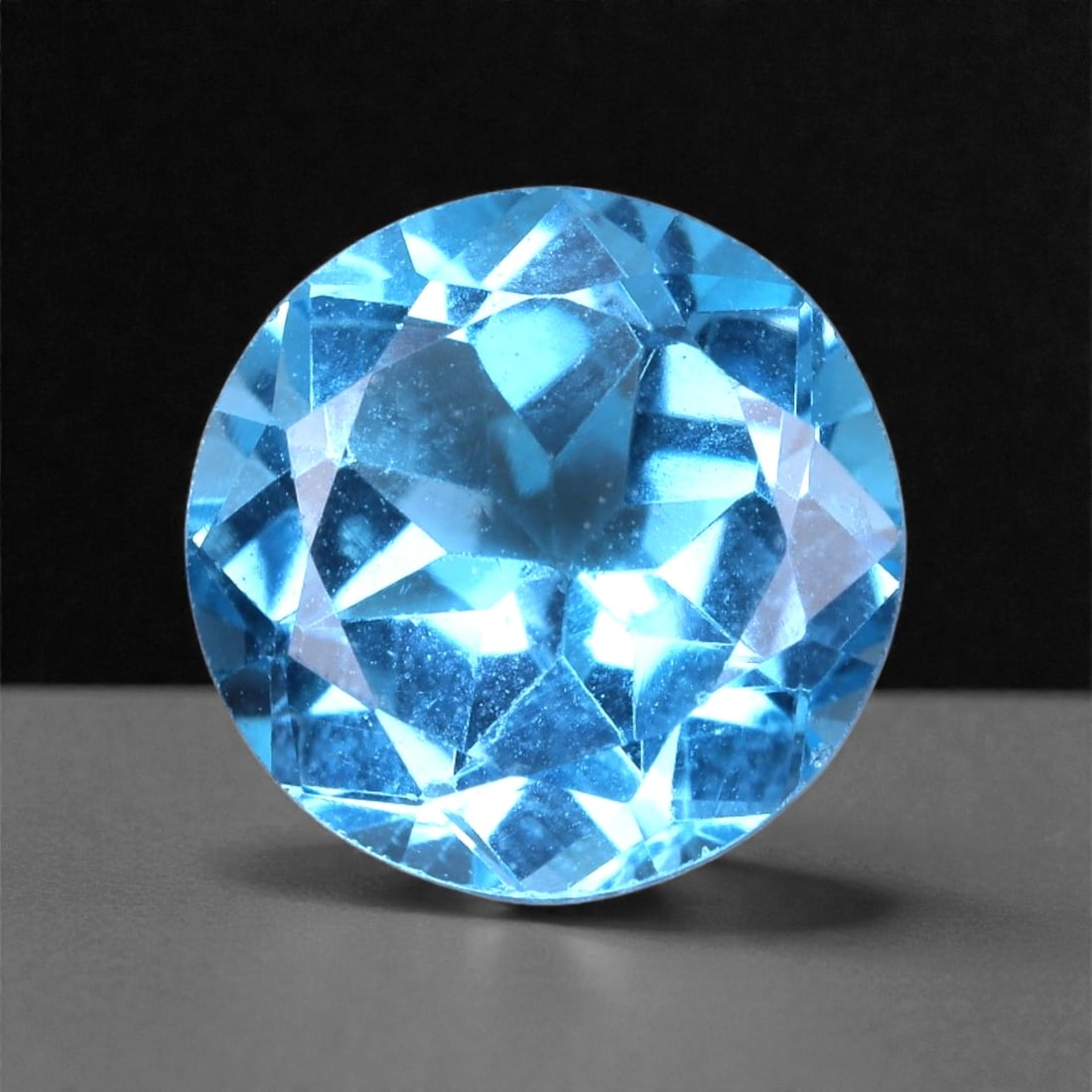3.38 Carats Swiss Blue Topaz Round - Natural Brazilian Gem, 63XB: This brilliant 3.38 carat Swiss blue topaz radiates with clarity and a vibrant electric blue tone, beautifully cut in a round shape for maximum sparkle. Measuring 8.9 x 5.5 mm, the gem exhibits a live