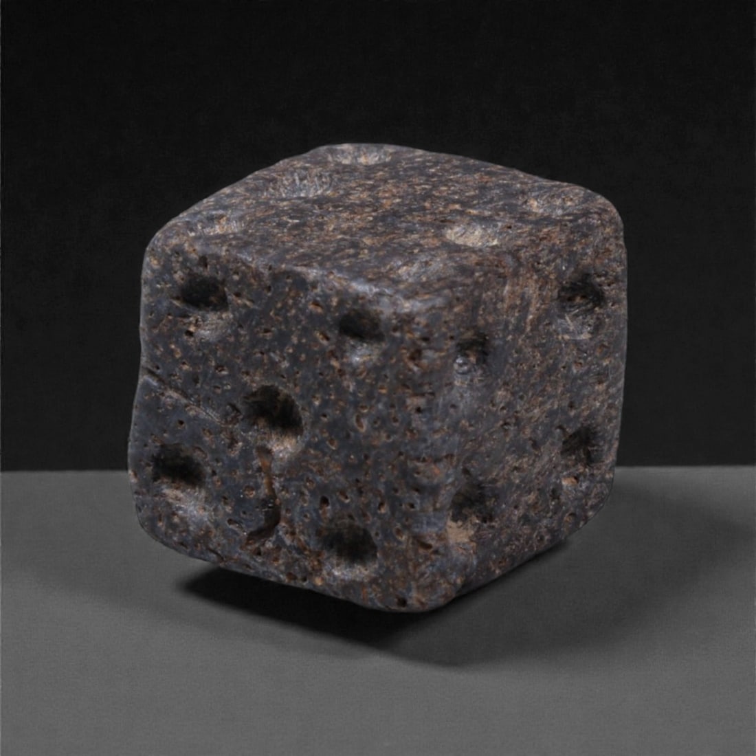 Ancient Roman Bone Gaming Die - Carved Dice, 1cm, 26ZD: Carved from dense animal bone, this miniature gaming die is carefully shaped into a cubic form with evenly proportioned faces and rounded edges softened through long use. The pips are drilled as shall