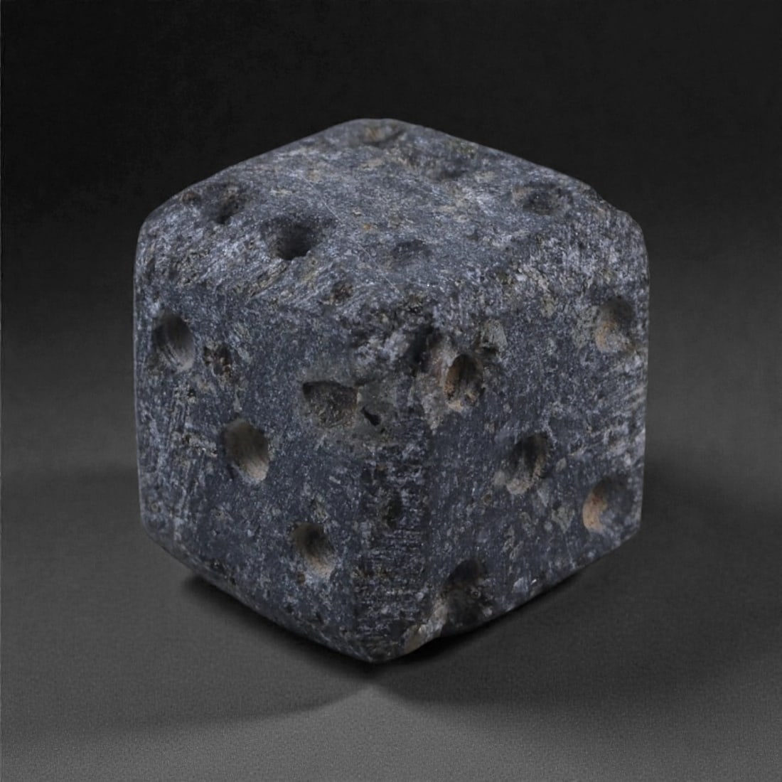 Ancient Roman Bone Gaming Die - Carved Dice, 1cm, 58E: Carved from dense animal bone, this miniature gaming die is carefully shaped into a cubic form with evenly proportioned faces and rounded edges softened through long use. The pips are drilled as shall