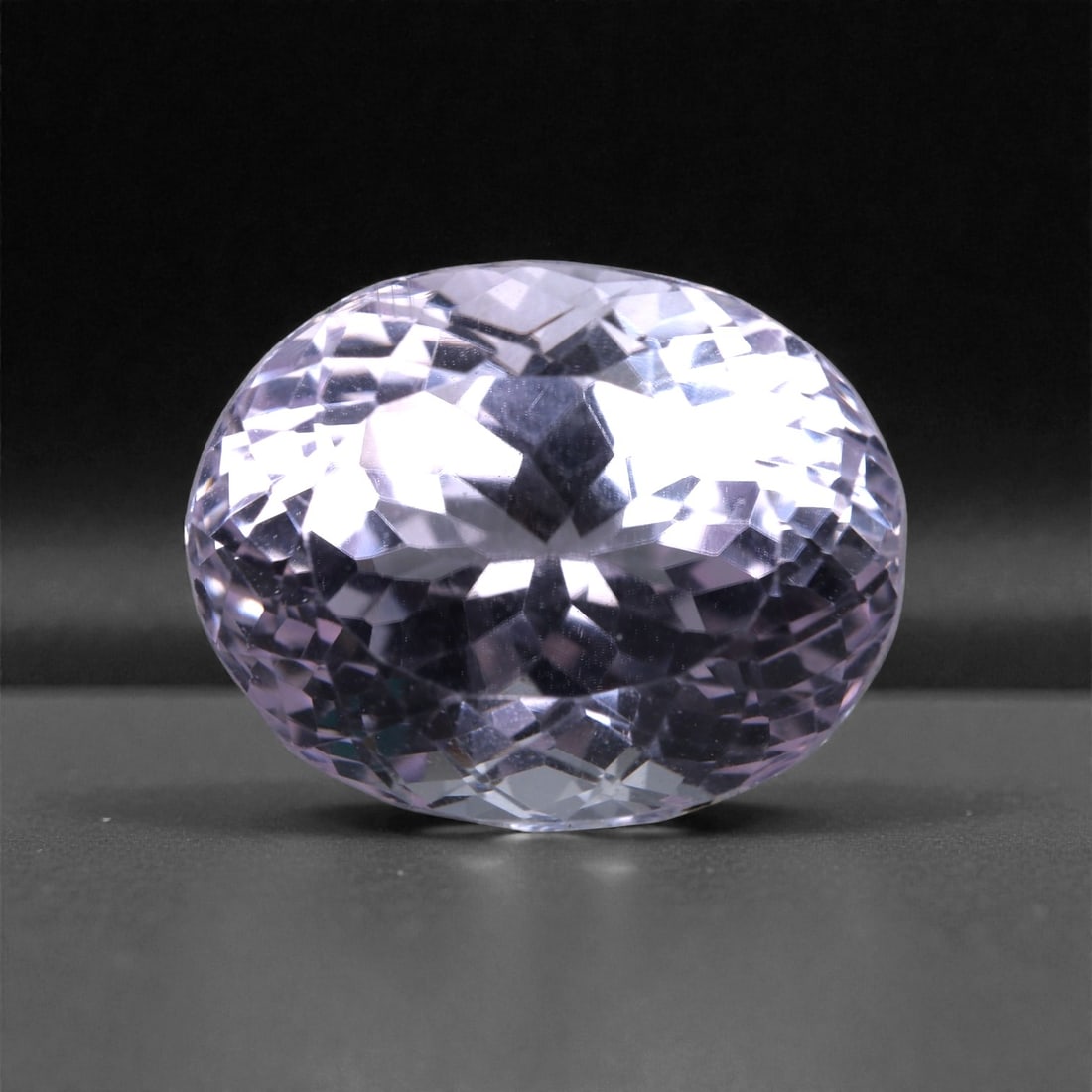 21.35 Carats Lavender Pink Kunzite Oval - Natural Afghan Gem, 54XB: This exquisite 21.35 carat kunzite dazzles with a soft, ethereal glow in delicate tones of lavender pink. Measuring 18.1 x 14.3 x 11.9 mm, the stone is expertly faceted into a full-bodied oval that ma