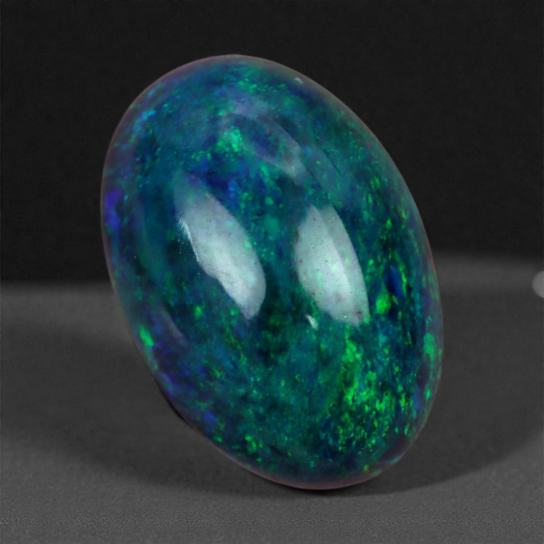 1.78 Carats Oceanic Blue-Green Smoked Black Welo Opal - Natural Ethiopian Gemstone 11.7x8.3mm, 86A: Evoking the depths of tropical seas, this opal glows with rich layers of marine blue, emerald green, and hints of indigo, shifting with mesmerizing fluidity under light. The overall effect is both tra