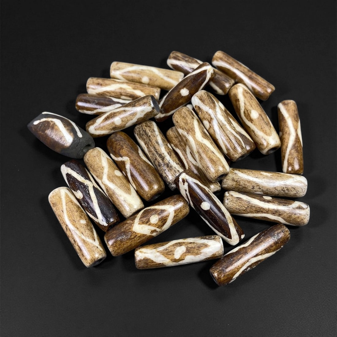 Mid-20th Century Tibetan Hand-Carved Wood Beads, 2.1-2.5cm, 9EP: A collection of Tibetan wood beads, each individually carved and polished, showcasing the natural beauty of the dark-stained grain with contrasting pale surface decoration. These mid-century examples