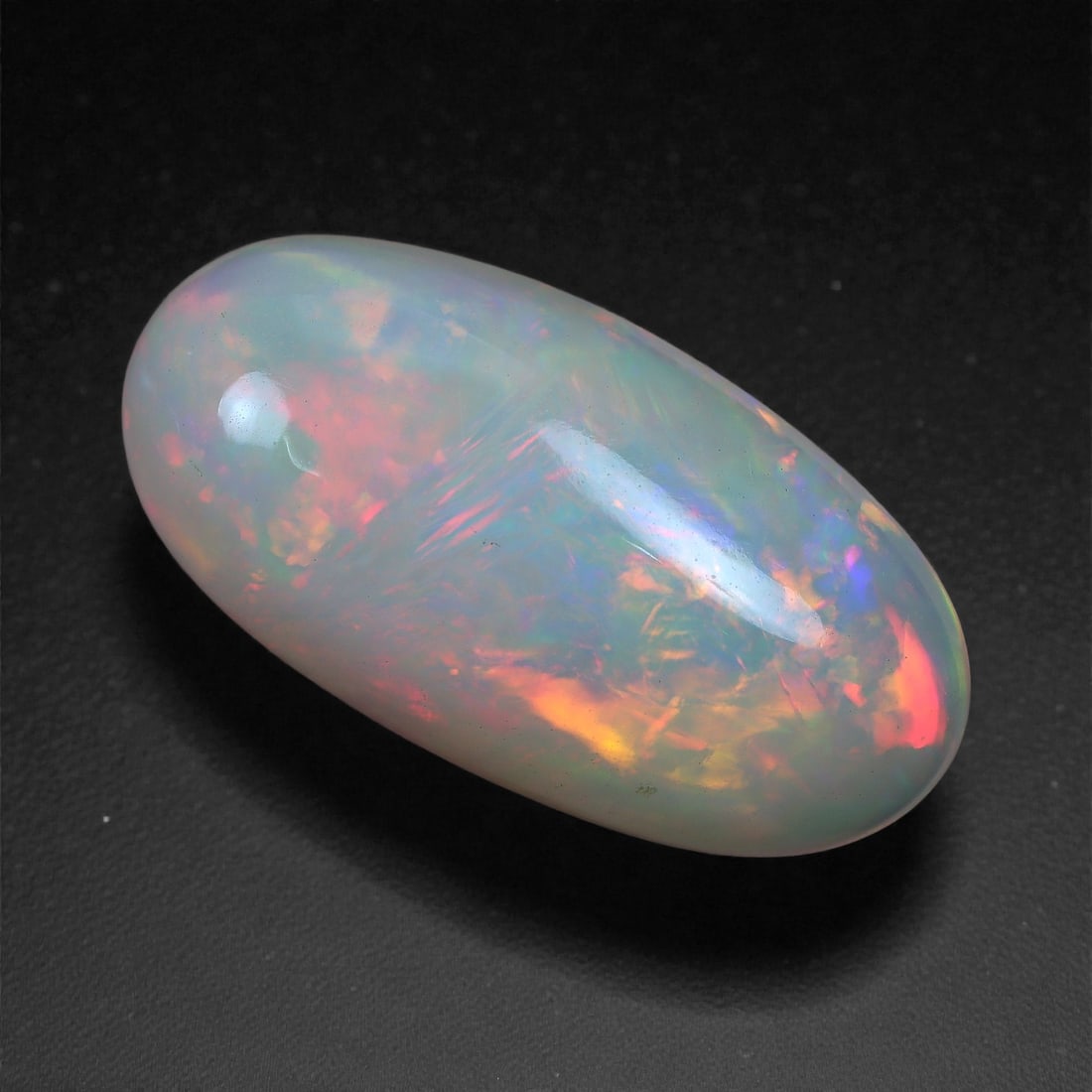 2.63 Carats Play-of-Color Welo Opal - Natural Ethiopian Gem 15x7mm, 31XC: This captivating Welo opal gleams with a luminous cascade of multi neon color that ripple across the stone's surface with every movement. The play-of-color is vivid and well-distributed, presenting a