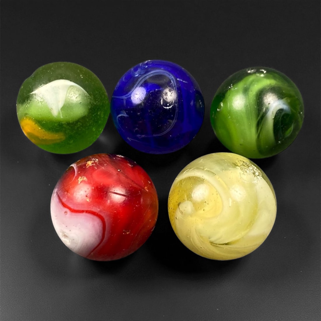 Vintage Glass Marbles Lot, Mid-20th Century, 1.6cm, 55EN: This charming lot of vintage glass marbles, dating from the mid-20th century, reflects the artistry and playfulness of early handmade and molded glass craftsmanship. These marbles were produced during