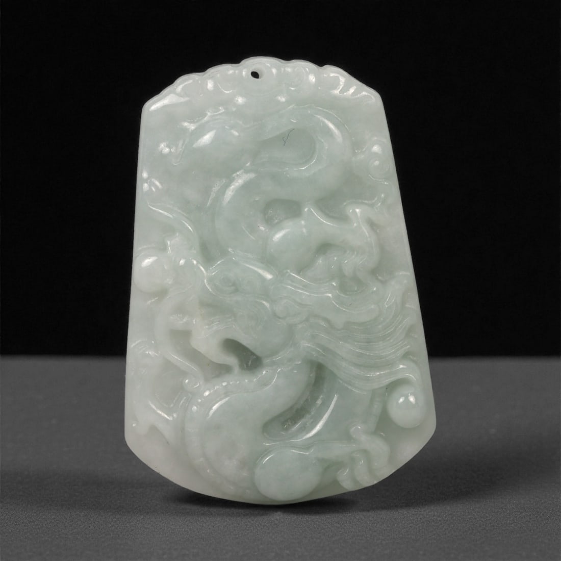 Chinese Jade Dragon Pendant - Carved Stone Plaque, 85ZD: Carved from pale celadon jade with soft translucency and gentle internal clouding, this small pendant plaque is worked in shallow relief with a stylized dragon emerging through flowing lines, rounded