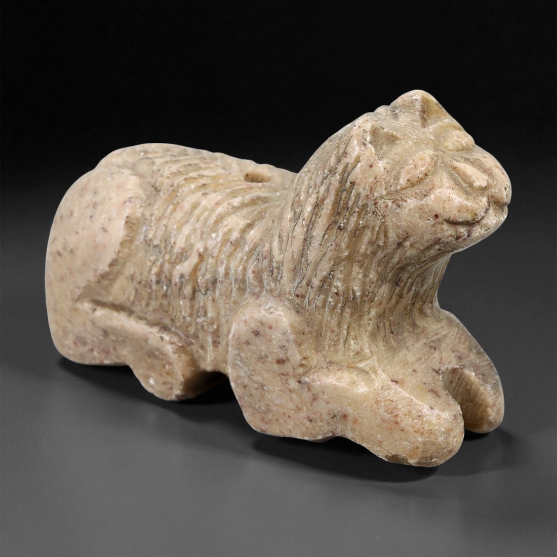 Ancient Akkadian Stone Feline Amulet, c. 2300-2100 BCE, 5.9cm, 3ER: This powerful feline amulet, carved from mottled beige stone with subtle reddish inclusions, dates to the Akkadian period of Mesopotamia (c. 2300-2100 BCE). Depicting a recumbent big cat - possibly a