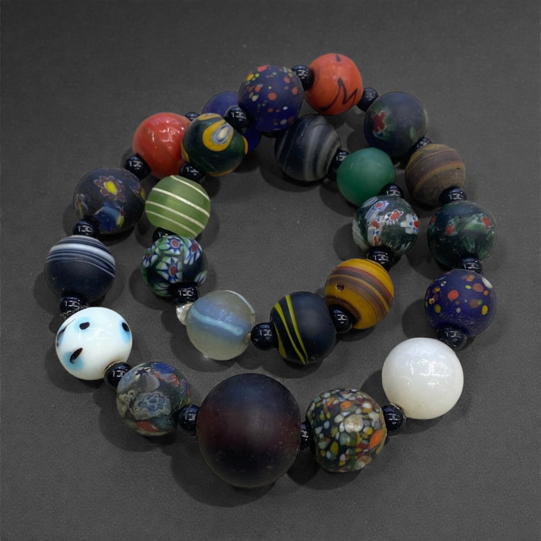 An Antique Glass Bead Strand, Late 19th-Early 20th Century, 113g, 40AA: Composed of a varied assemblage of hand-formed glass beads strung as a continuous strand, the group includes spherical and slightly ovoid elements executed in a wide range of colors and decorative tec
