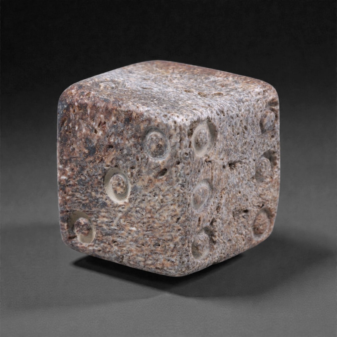 Ancient Roman Bone Gaming Die - Carved Dice, 1.5cm, 43ZD: Carved from dense animal bone, this miniature gaming die is carefully shaped into a cubic form with evenly proportioned faces and rounded edges softened through long use. The pips are drilled as shall