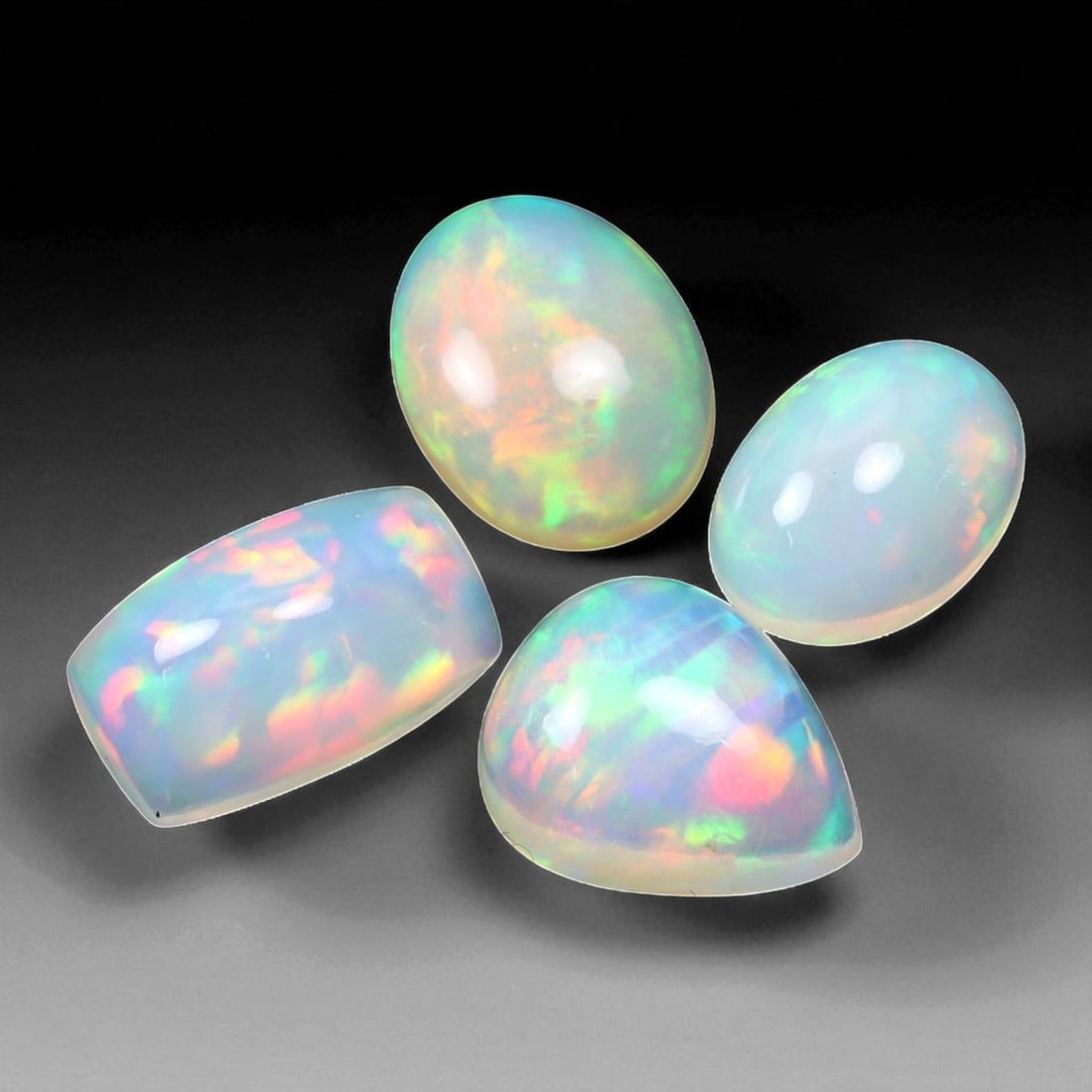 10.25 Carats Multi-Color Welo Opal Lot - Natural Ethiopian Stones, 13XC: This radiant group of Welo opals displays a mesmerizing interplay of color that dances across the surface with every shift of light. Electric flashes of green, orange, and red ripple through a translu