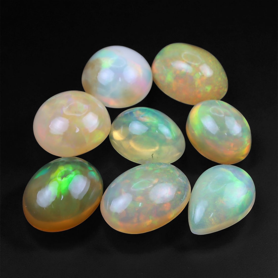 10.44 Carats Neon Play-of-Color Opal Selection - Natural Ethiopian Cabochons - 7 to 10 mm, 98XE: This luminous selection of opals radiates a dynamic spectrum of neon hues, with flashes of electric green, vivid orange, and spectral blue dancing across each dome. Their translucent base allows the i
