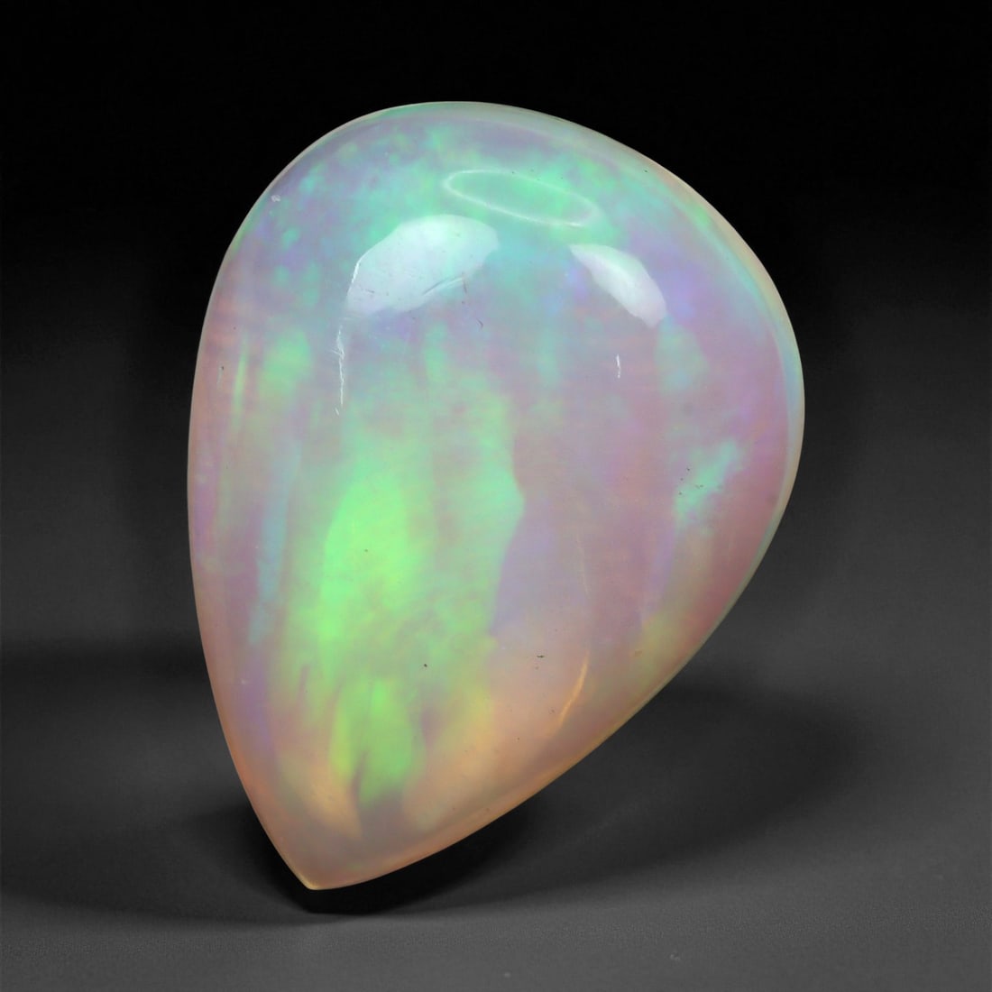 3.49 Carats Pastel Neon Welo Opal Cabochon - Natural Ethiopian Gemstone, 59XE: This glowing Welo opal shimmers with delicate flashes of mint green, lavender, sky blue, and soft amber beneath a translucent, honey-toned body. Its internal light play is gentle yet vivid, with broad