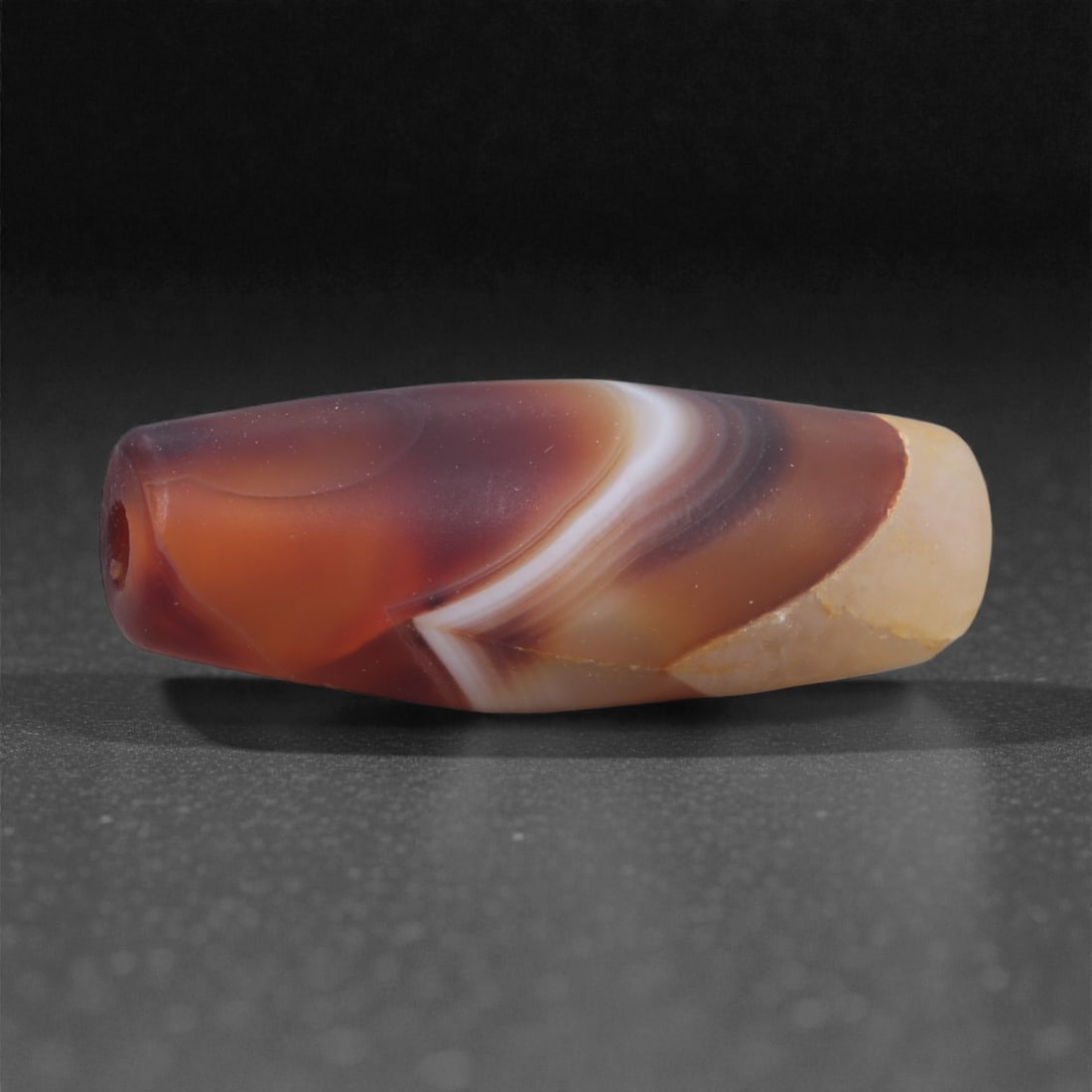 Antique Agate Bead - Himalayan Chung Dzi Amulet, 2.9cm, 70X: The bead is carved from banded agate, carefully shaped into a short cylindrical form with gently rounded ends and a central perforation. The stone displays a natural contrast between a pale central zo