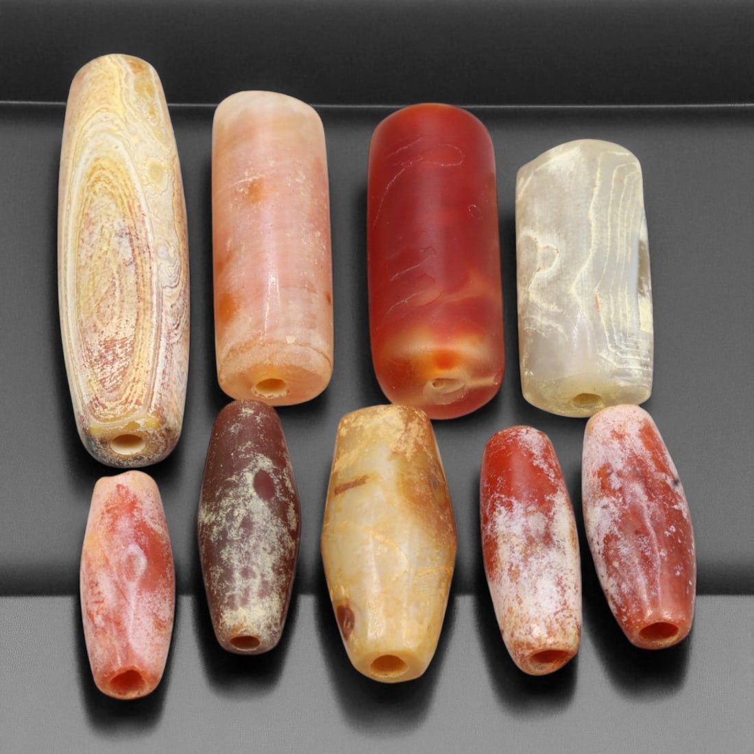 Ancient Indus Valley Carnelian and Agate Beads, c. 2500-1800 BCE, 1.8-3.7cm, 46EA: This striking collection of ancient carnelian and agate beads originates from the Indus Valley Civilization, dating to circa 2500-1800 BCE. The elongated cylindrical and barrel forms, rendered in vivi