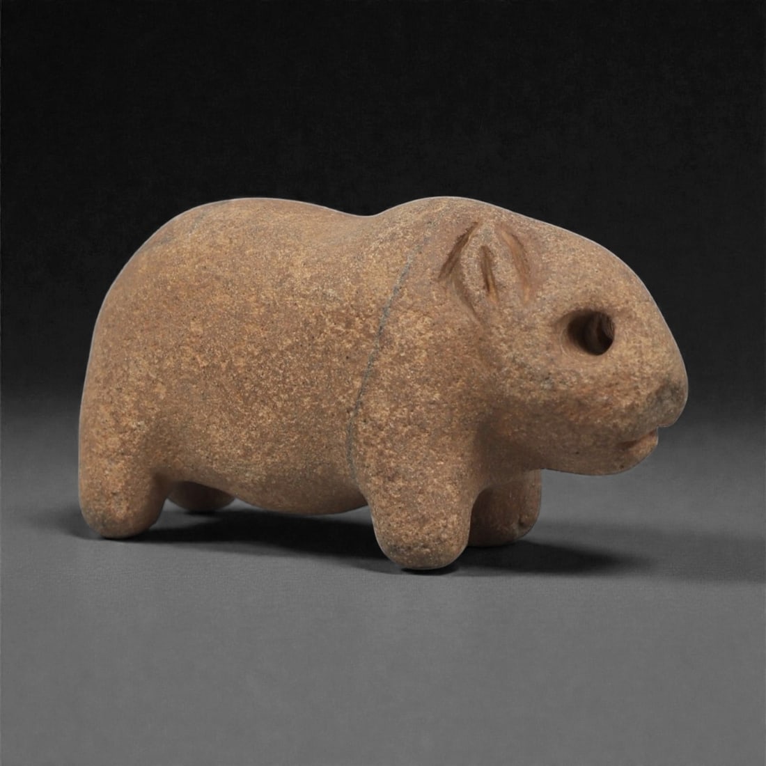 A Near Eastern Stone Zoomorphic Figurine, 3rd Millennium BCE, 10LF: Carved from a brown stone with fine surface wear and natural inclusions, the object is shaped as a small quadruped with a rounded body and short legs. The head is defined by a drilled circular eye, a