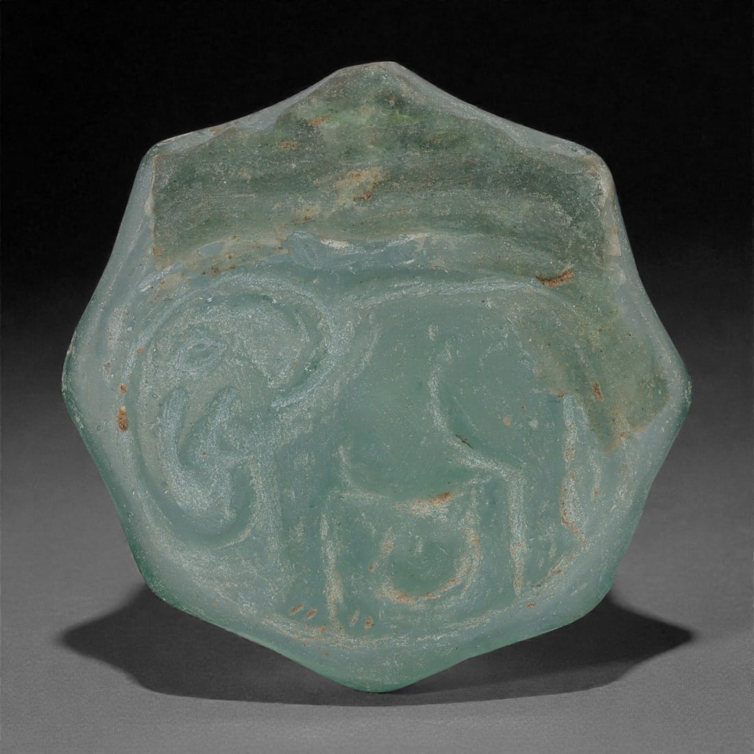 An Early Islamic Molded Green Glass Octagonal Roundel with Elephant, 8th-10th Century CE, 21LP (1 of 2)